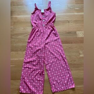 Girls romper, pink and white design, adjustable shoulder straps, down to ankles.